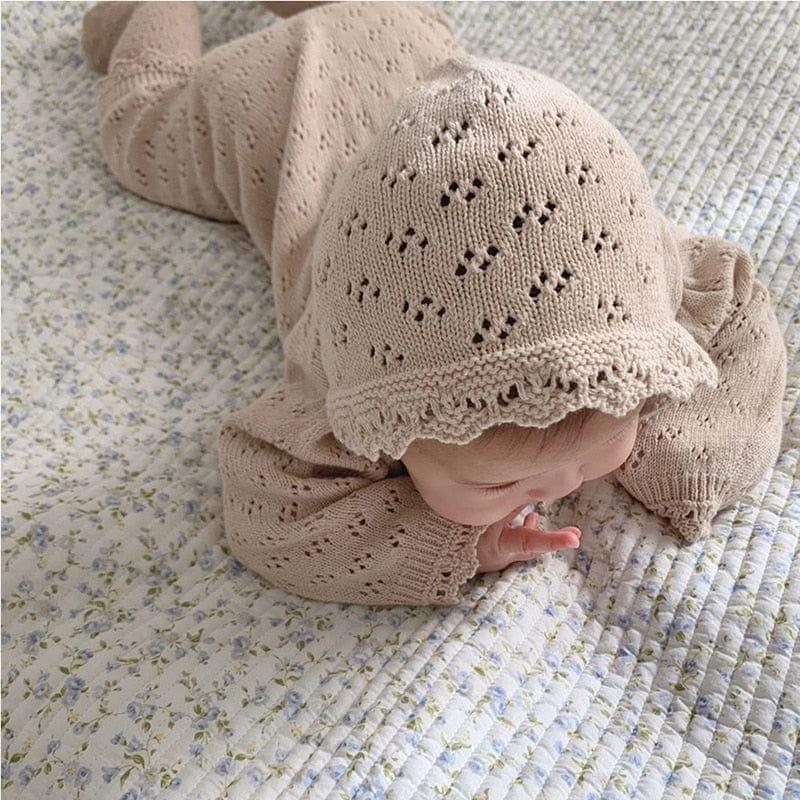 beige knitted baby romper with hood in size for newborns featuring delicate lace trim