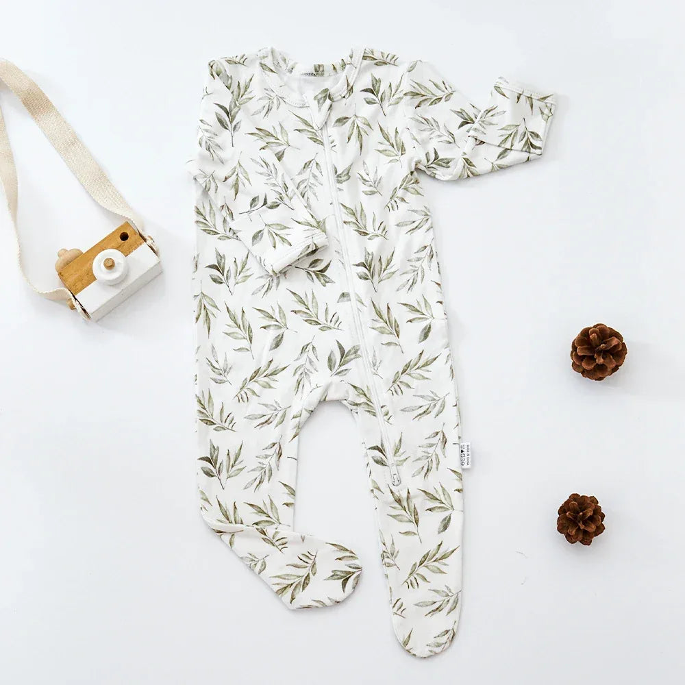 White baby romper with green leaf print, long sleeve, footed design for infants