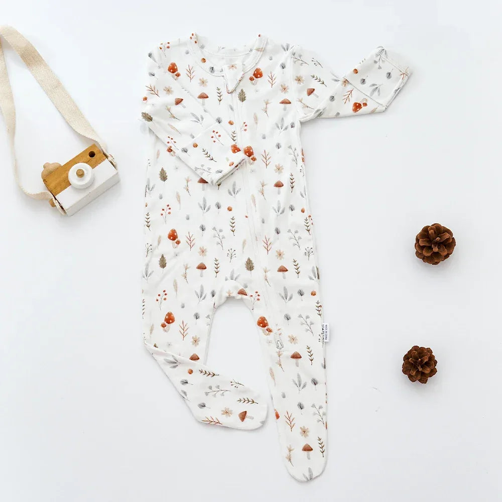 White baby romper with long sleeves and mushroom and leaf print for infants