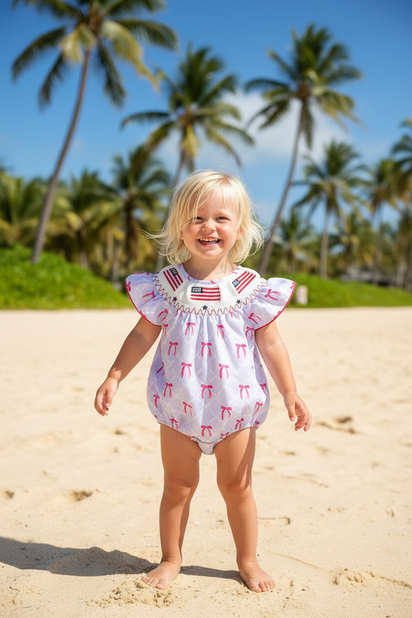 baby romper with white and pink bow pattern and American flag smocked collar for infants