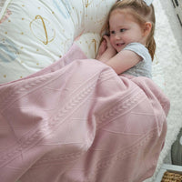 Rose knit baby blanket in soft pink with textured cable knit design for newborns and toddlers