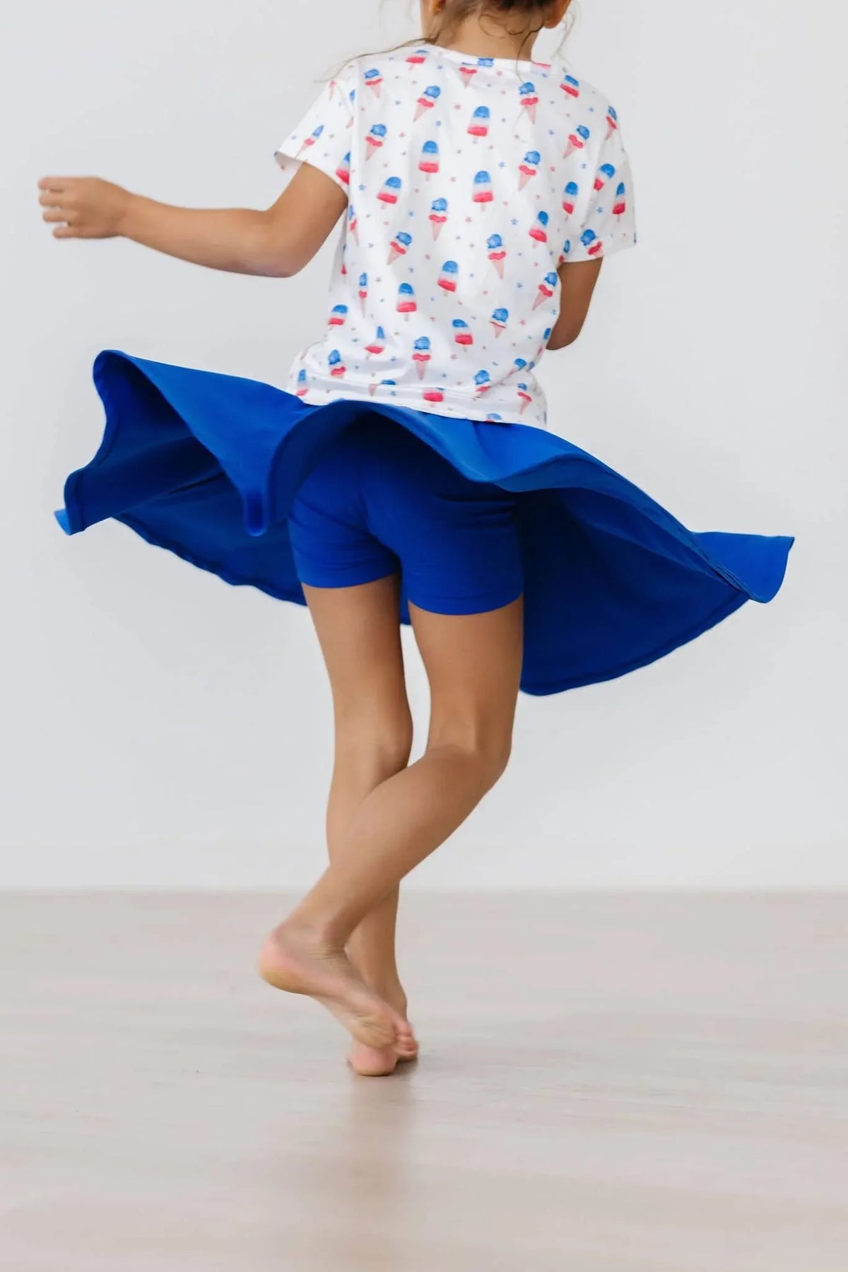 Girl wearing royal blue twirl skort for girls spinning with skirt flared out