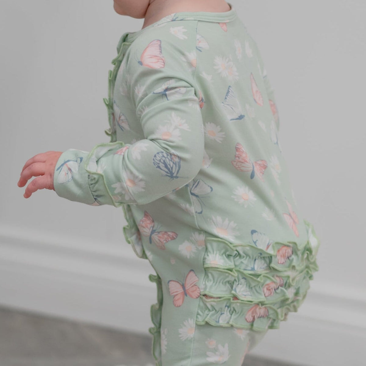 Mint Butterfly Daisy Bamboo Ruffle Baby Footie in soft bamboo with butterfly and daisy print, ruffles, 2-way zipper.