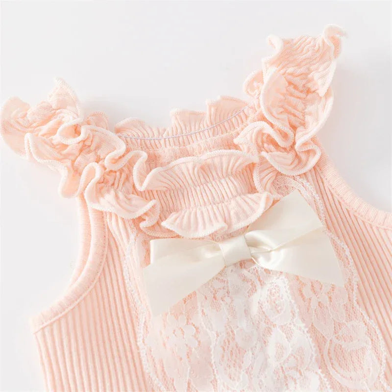 close up of a pink ruffle knit baby romper with lace front and white bow for infants