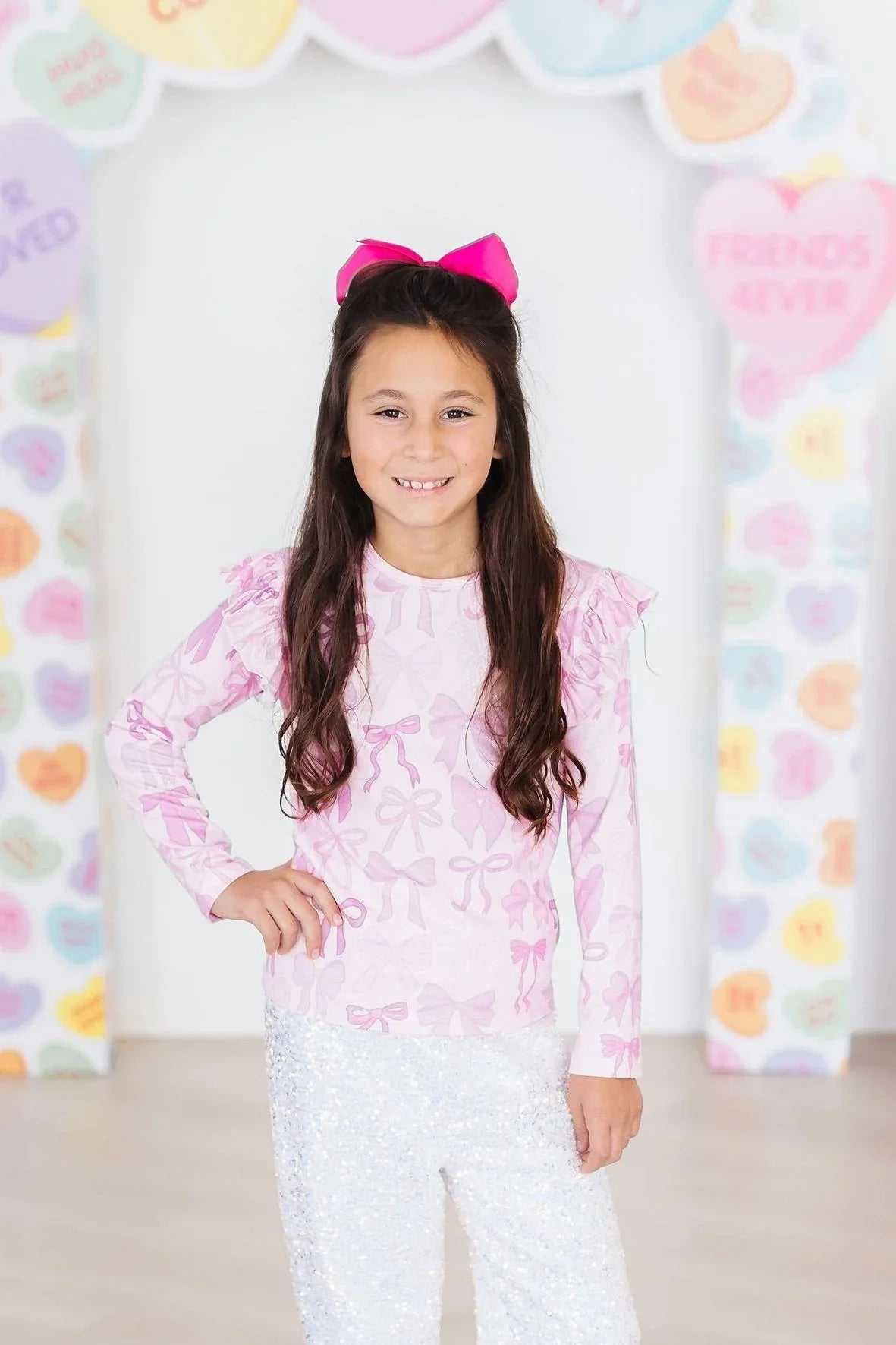 girls light pink ruffle tee long sleeve with bow pattern and shoulder ruffles
