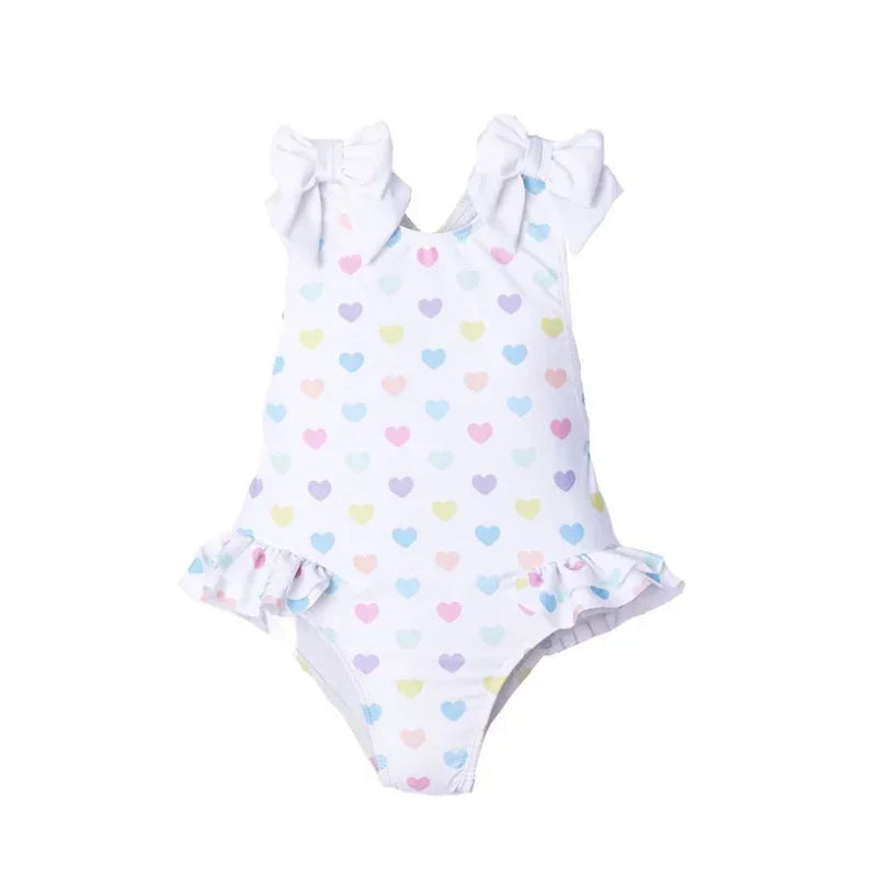White ruffled heart print toddler swimsuit with pastel hearts and bow shoulder straps