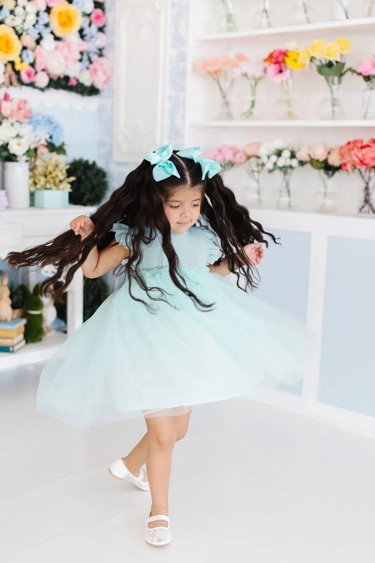 Toddler girl wearing a sage shimmer tutu dress for girls by Mila & Rose with matching bows