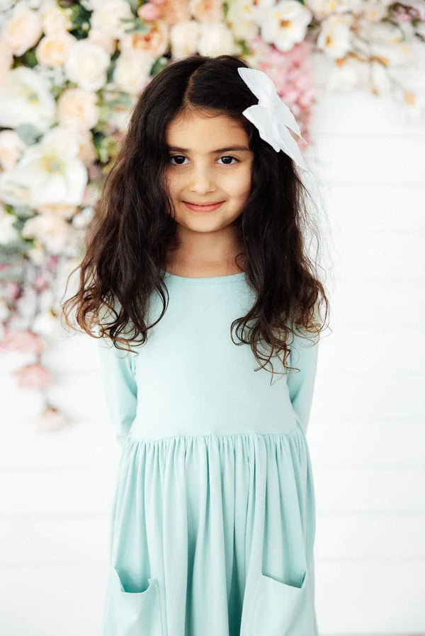 Sage twirl dress for girls with sleeves, with pockets, worn by young girl