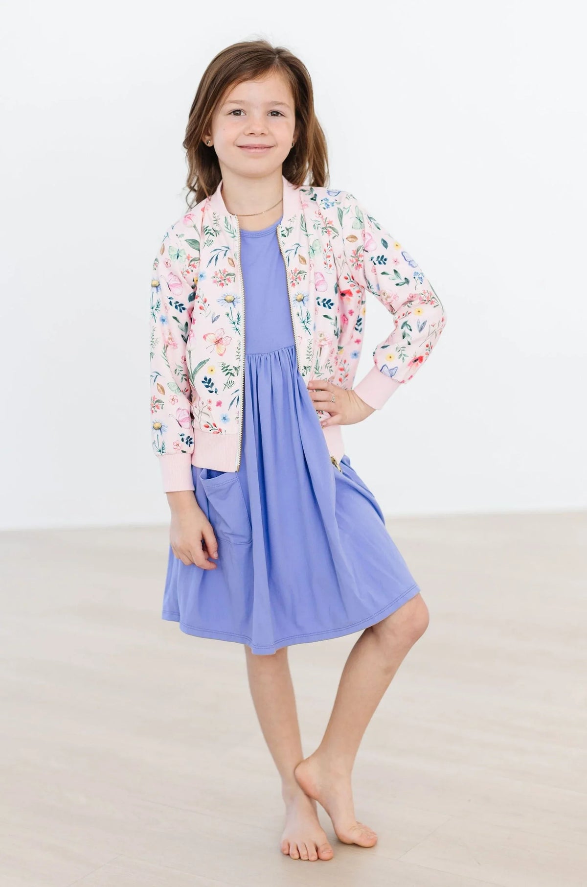 Girls pink floral satin jacket with ribbed cuffs and collar over blue dress