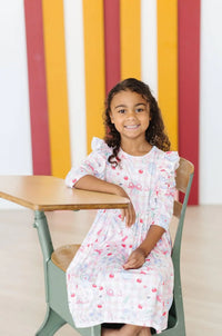 Girls pink and white school days girls ruffle dress with 3/4 sleeves seated at school desk