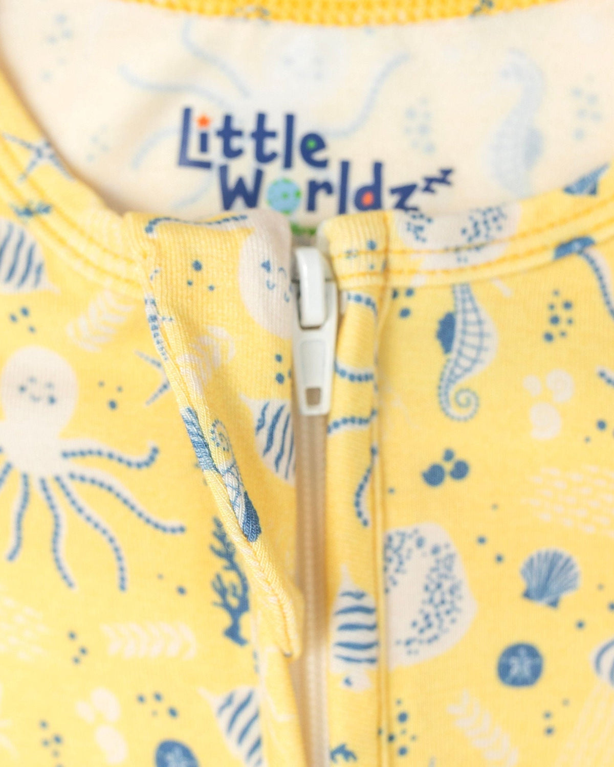 Yellow bamboo toddler romper featuring blue sea creature print and front zipper detail for comfortable sleepwear.