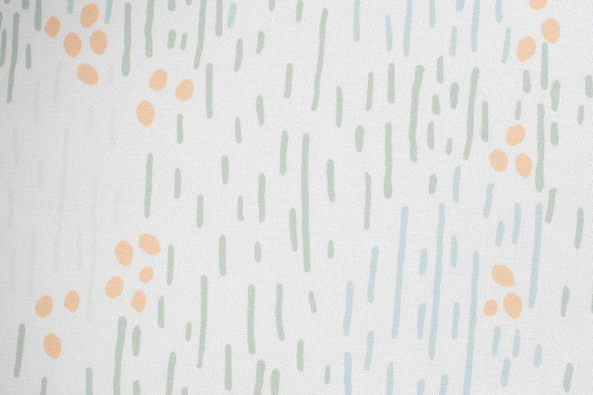 Sealy floor cushion with white fabric and soft green and peach abstract dot pattern for baby use