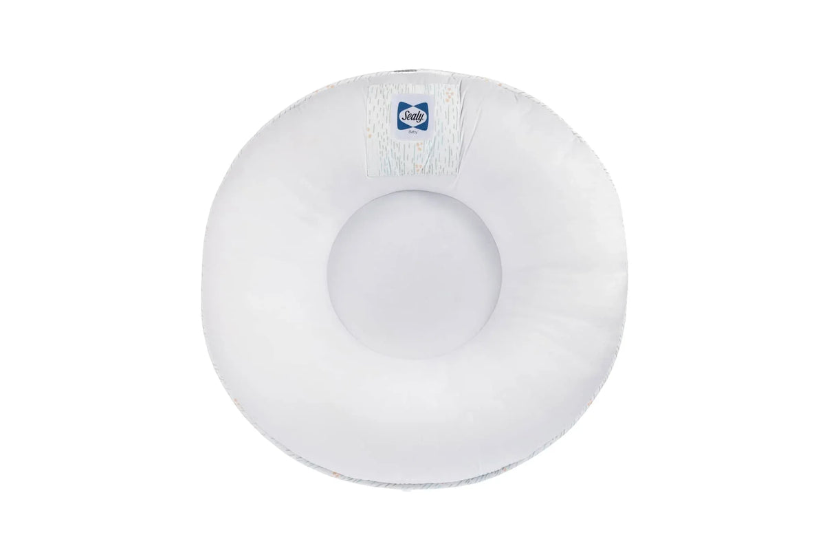 White Sealy floor cushion for newborns with soft padded center and Goosewaddle logo
