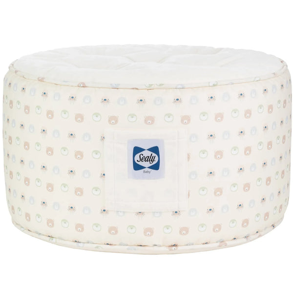 Round beige toddler animal pouf seat with pastel animal faces and Sealy Baby logo patch