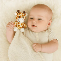 Cream cotton security blanket by Me Lovey with a baby holding a small giraffe plush toy
