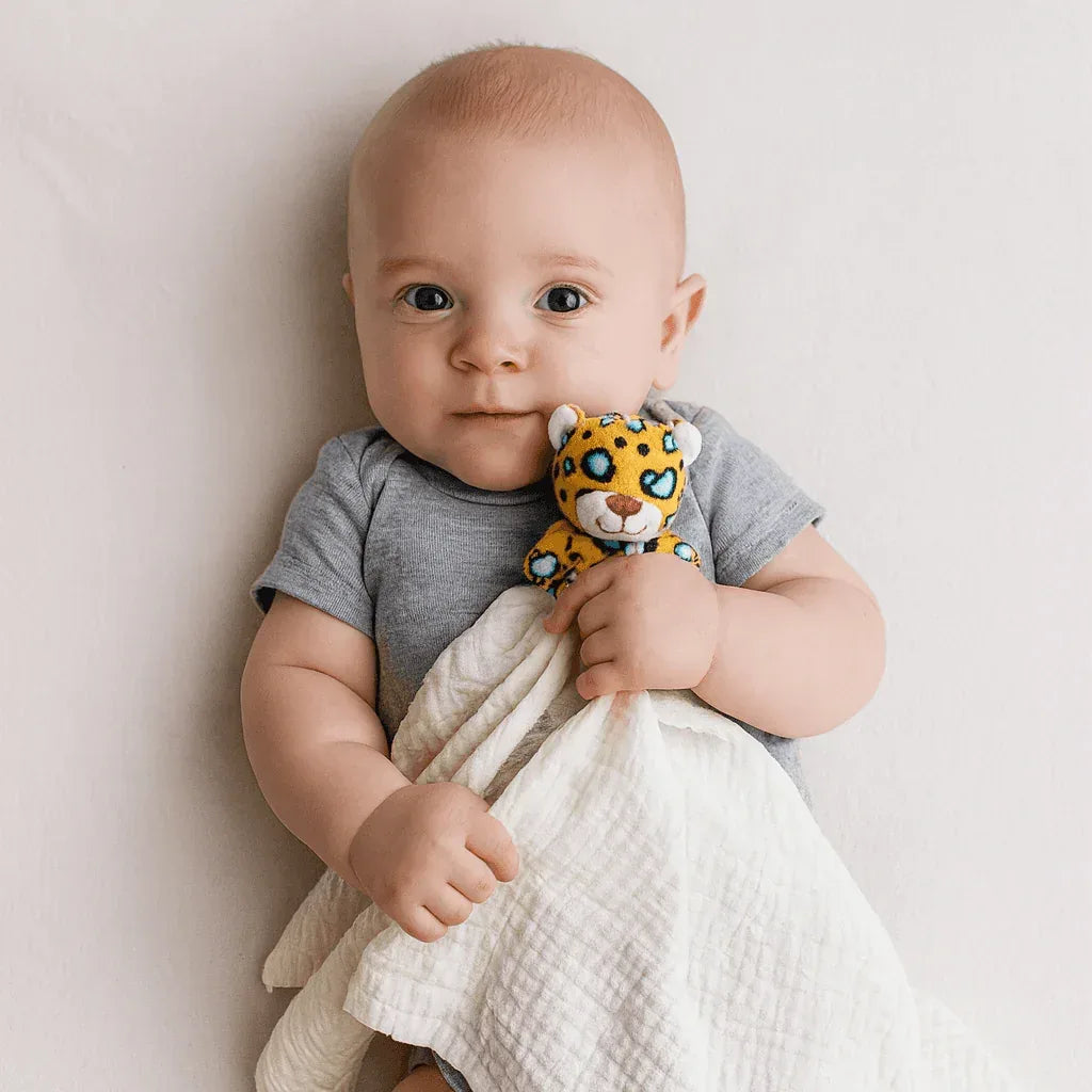Baby holding Me Lovey white muslin security blanket toy with yellow leopard plush head