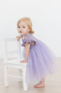 Toddler girl wearing lavender shimmer party dress for girls with ruffle sleeves and tutu skirt