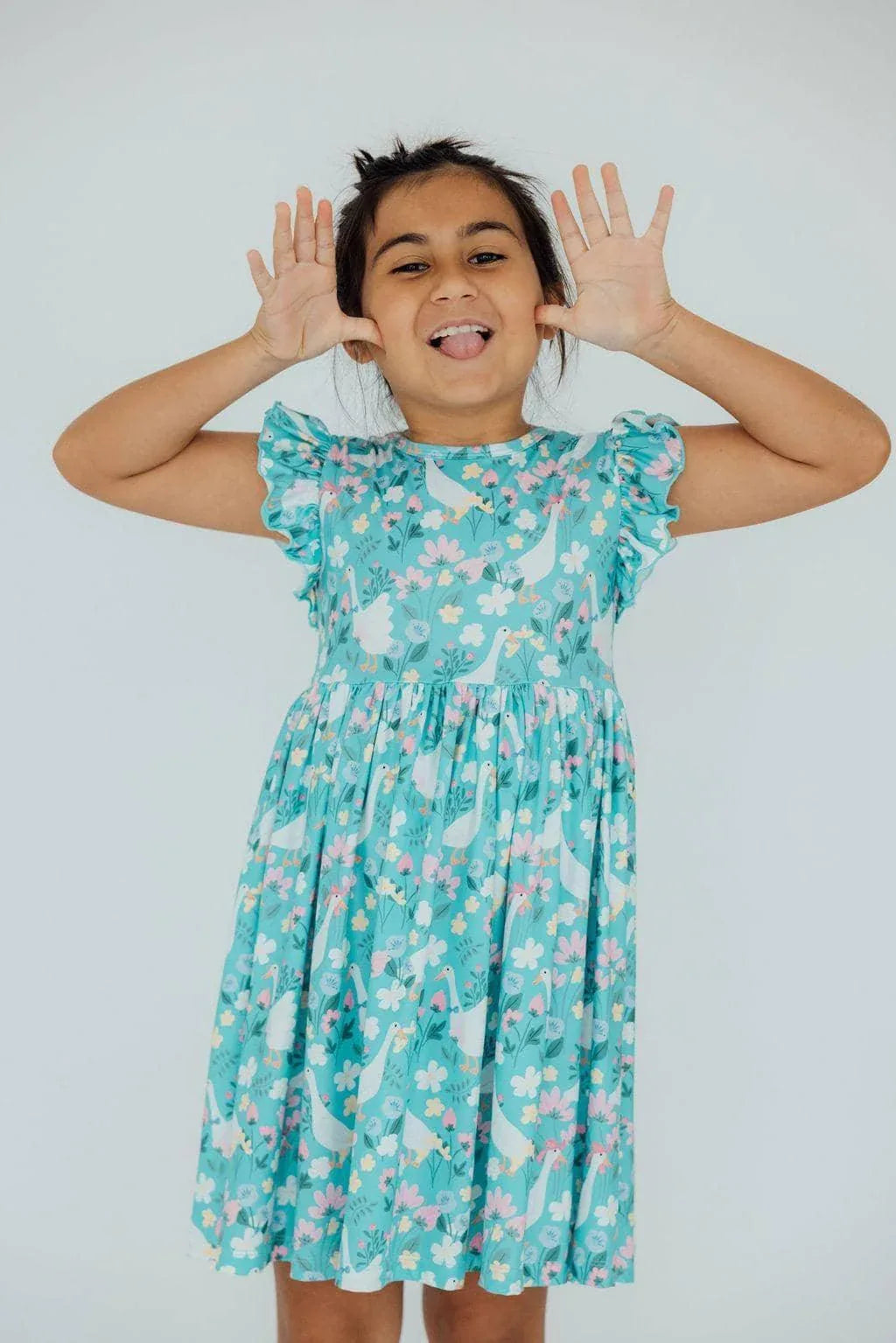 Girls turquoise silly goose flutter sleeve dress with white and pink floral pattern, knee-length twirl dress