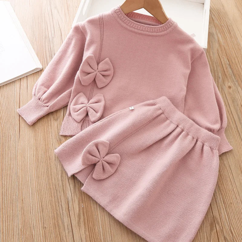 baby pink skirt set for girls with long sleeve top and bows on top and skirt