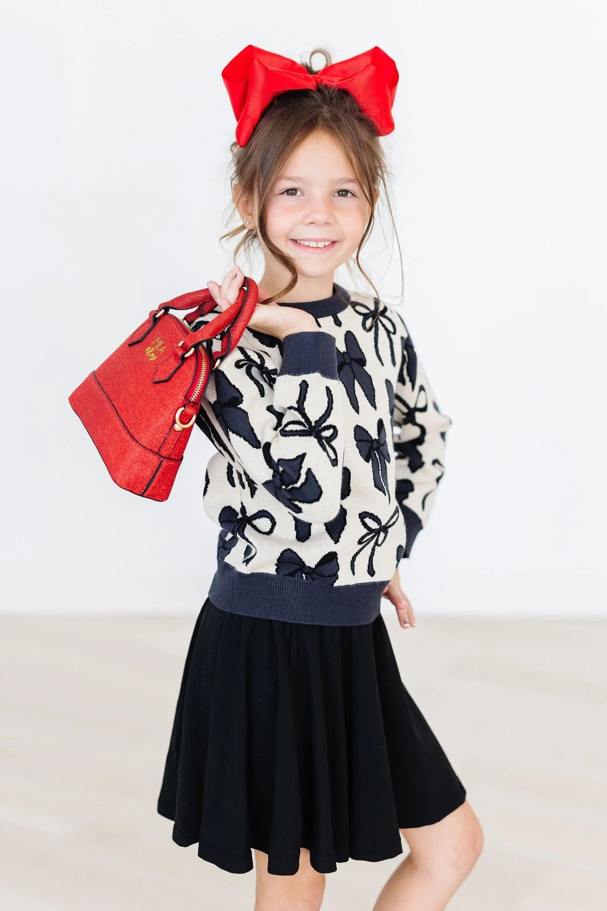 Girls cream and black bow print knit sweater, long sleeve by Mila & Rose with navy cuffs