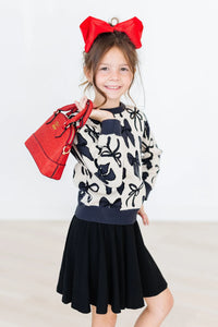 Girls cream and black bow print knit sweater, long sleeve by Mila & Rose with navy cuffs