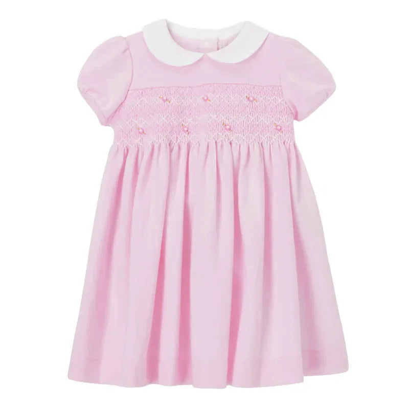 Baby pink smocked dress with white Peter Pan collar and short puff sleeves for infants
