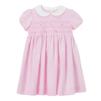 Baby pink smocked dress with white Peter Pan collar and short puff sleeves for infants