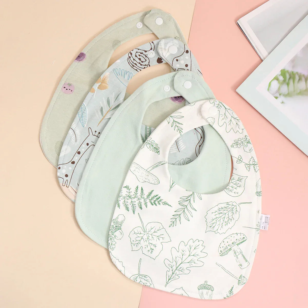 Soft cotton baby bib set with green leafy and animal prints for infants, adjustable snap closure