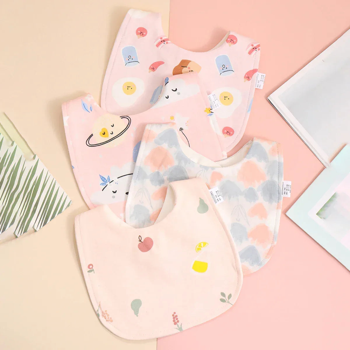 Soft cotton baby bib set with pastel pink and cream colors for infants with cute printed designs