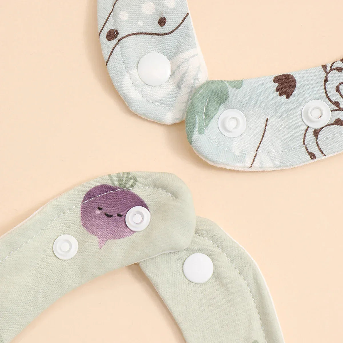soft cotton baby bib set in pastel green and blue with animal and vegetable prints, adjustable snap closures