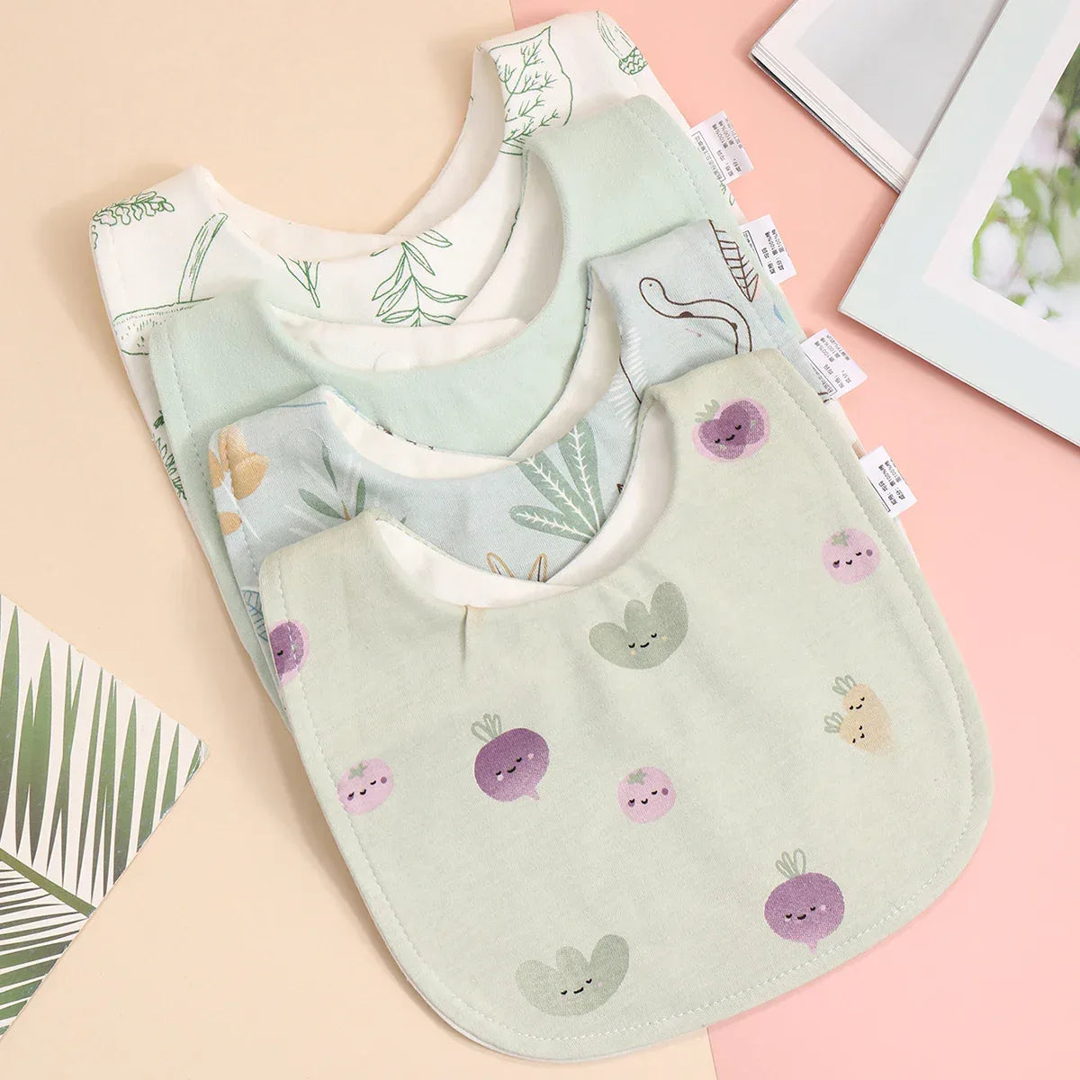 Soft cotton baby bib set with pastel green and white colors featuring cute vegetable prints for infants