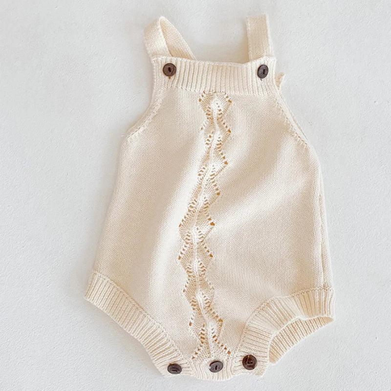 Cream soft knit baby romper for infants with button straps and decorative front pattern