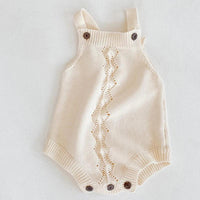 Cream soft knit baby romper for infants with button straps and decorative front pattern