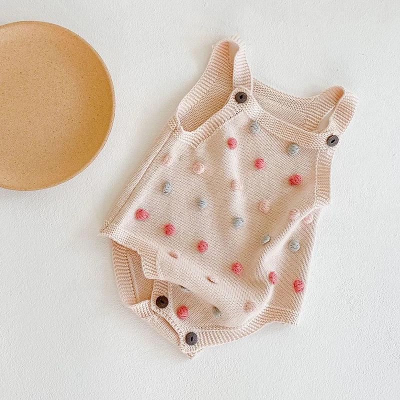 Soft knit baby romper in light beige with colorful pom pom details for infants