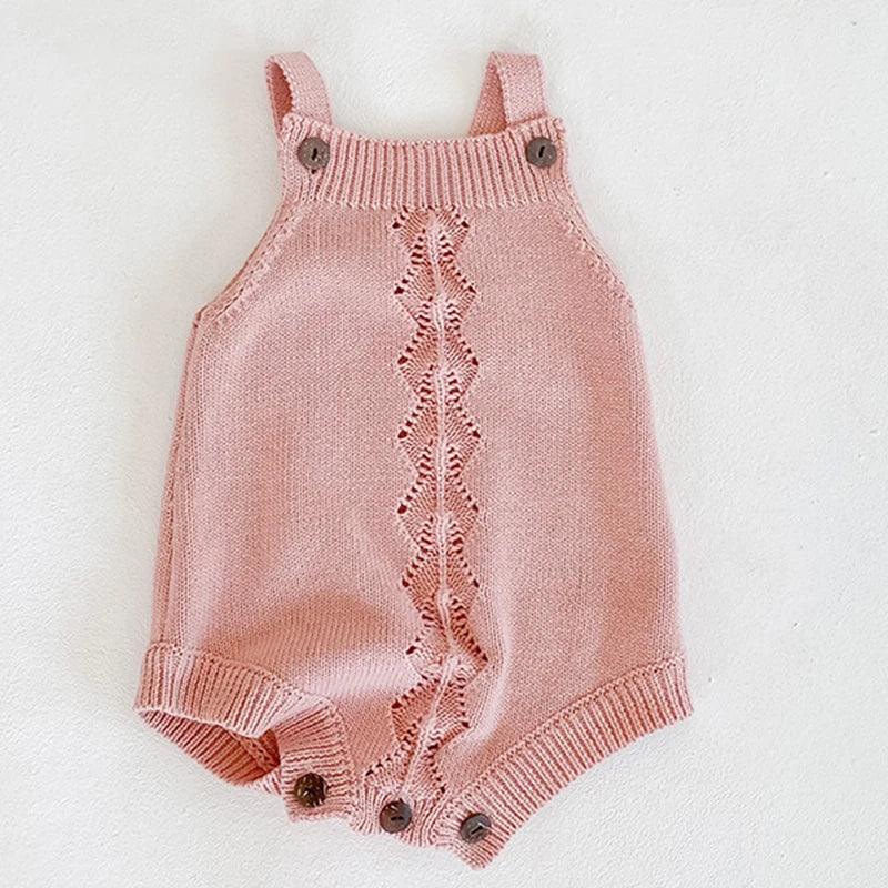 pink soft knit baby romper for infants with button straps and decorative central pattern