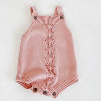 pink soft knit baby romper for infants with button straps and decorative central pattern