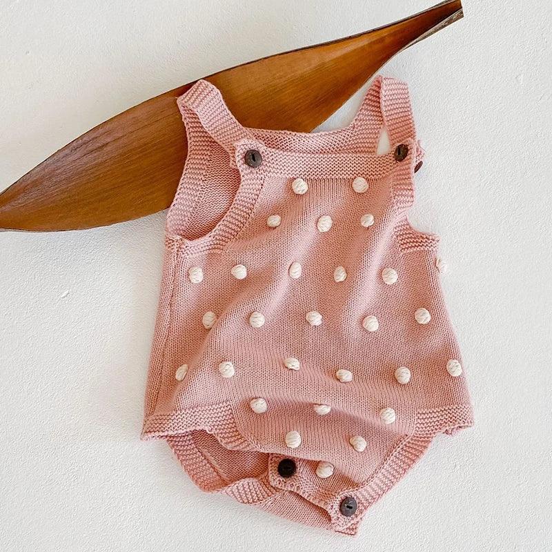 pink soft knit baby romper with white pom pom details for babies 0-6 months