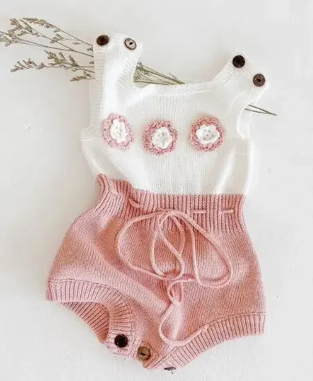 Soft knit baby romper in white and pink with flower appliques and button straps for infants