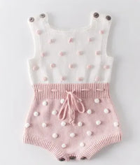 soft knit baby romper in white and pink for infants with button straps and textured dot detail