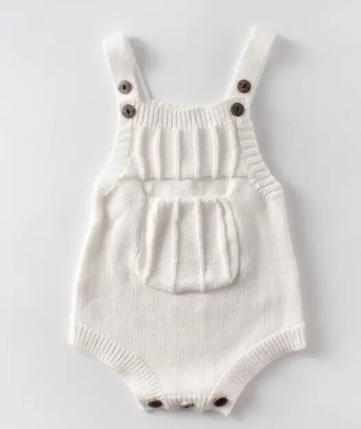 White soft knit baby romper with front pocket and button straps for newborns