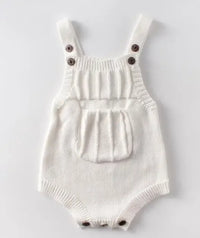 White soft knit baby romper with front pocket and button straps for newborns