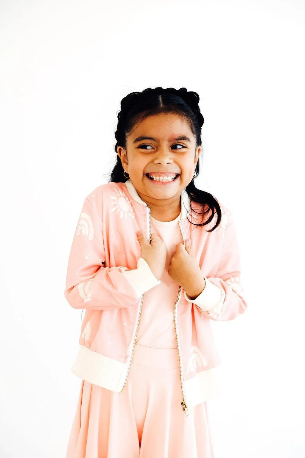 soft pink satin jacket for girls with white cuffs and zipper, worn by smiling young girl
