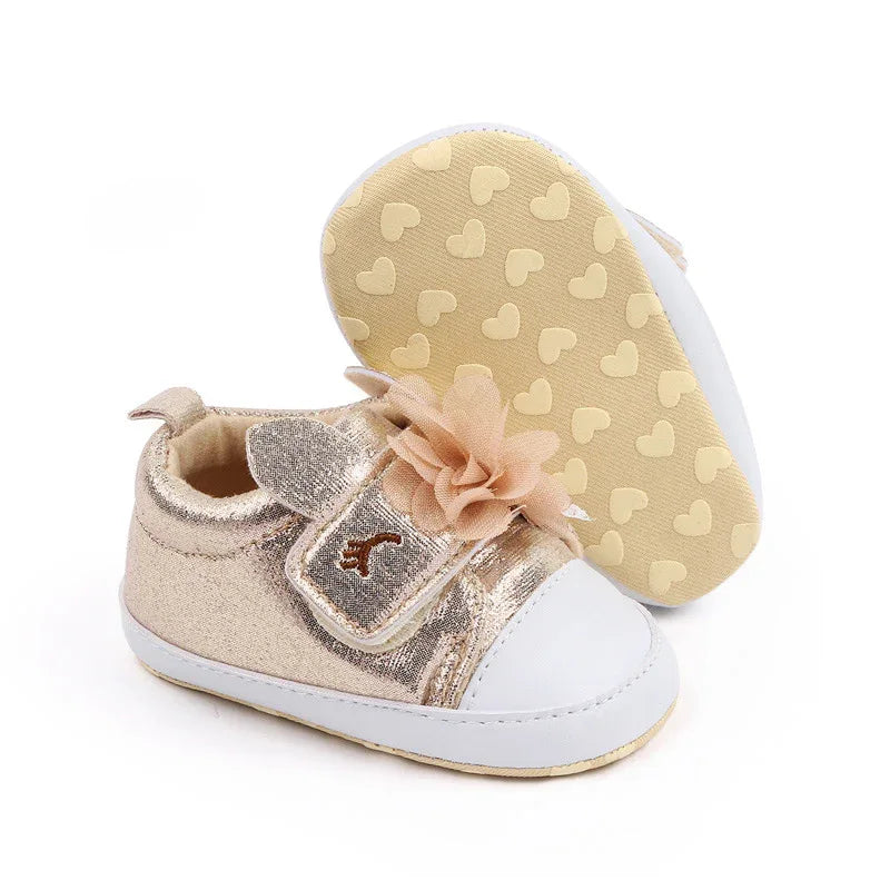 gold and white soft sole baby shoes with flower decoration for infants showing sole with heart patterns