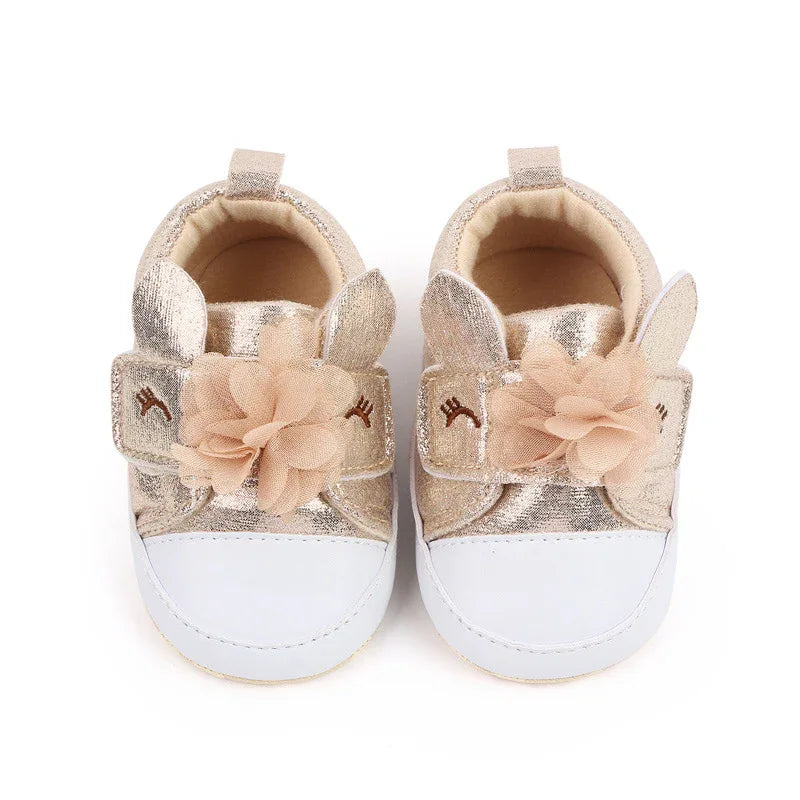 gold and white soft sole baby shoes with flower and bunny ear design for infants