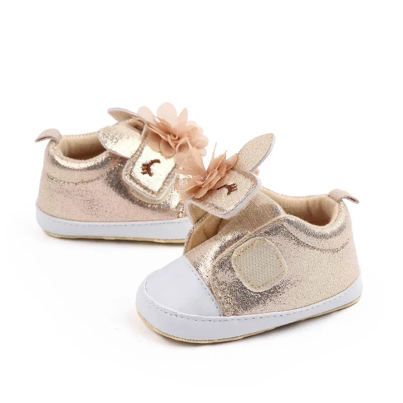 Gold glitter soft sole baby shoes with white toe cap and flower detail for infants
