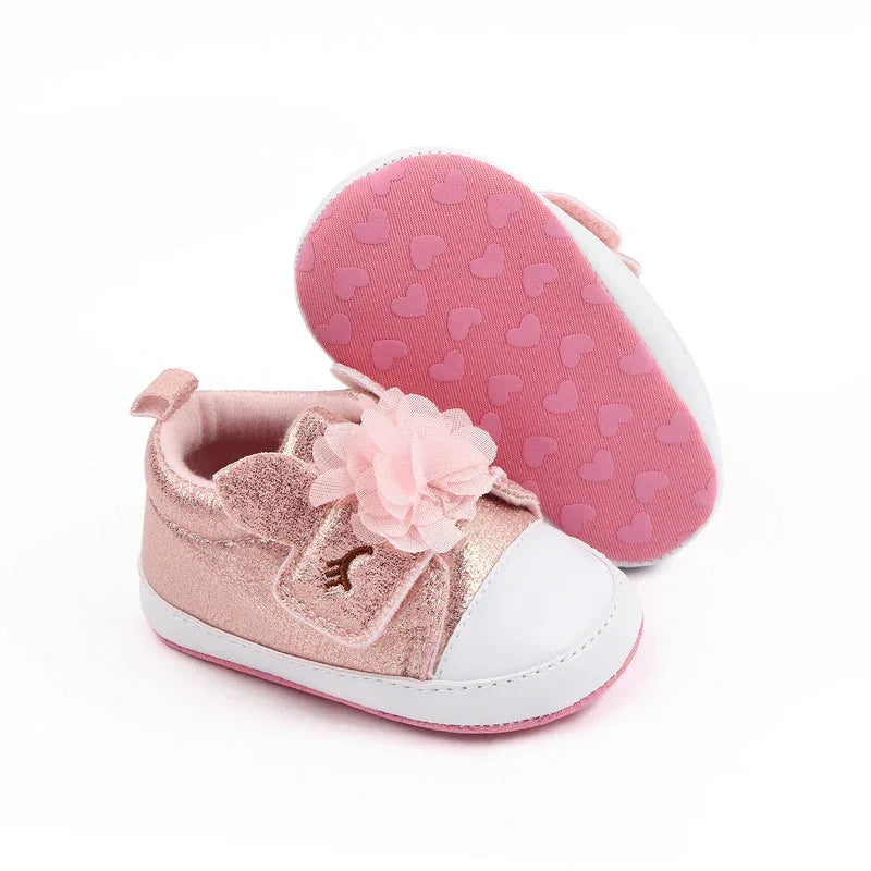 pink soft sole baby shoes with flower and bunny ears for newborns displayed on white background