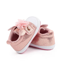 pair of pink glitter soft sole baby shoes with flower decoration for infants