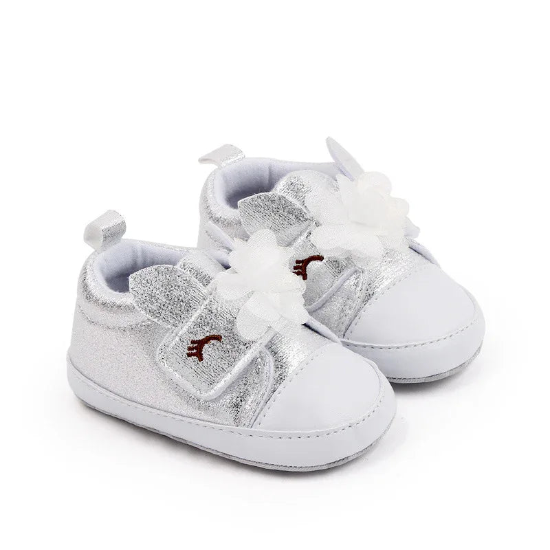Silver soft sole baby shoes with white flower and bunny ear details for infants