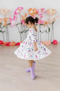 girl wearing white space print twirl dress for girls with 3/4 sleeves spinning indoors