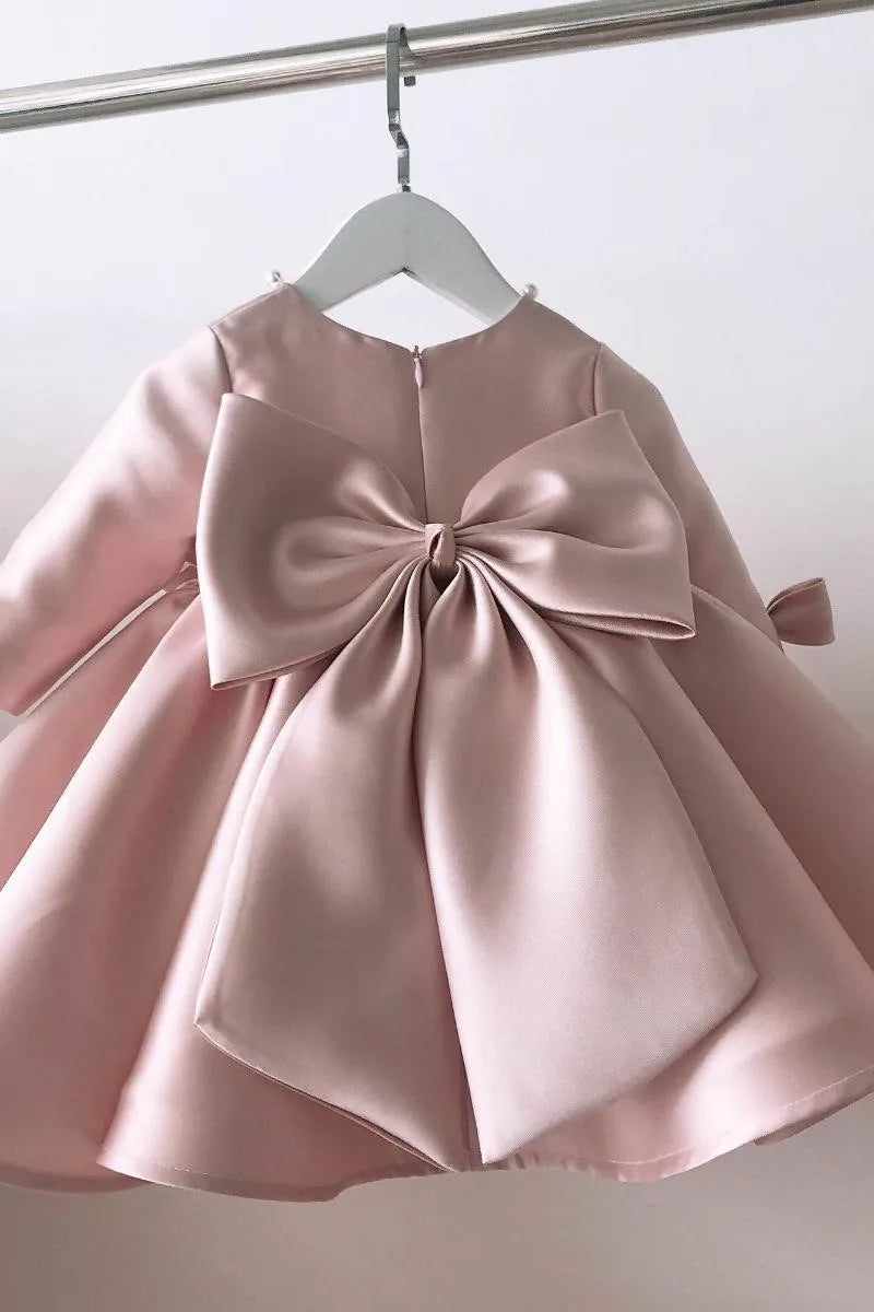 baby pink special occasion dress for infants with large bow back detail long sleeve